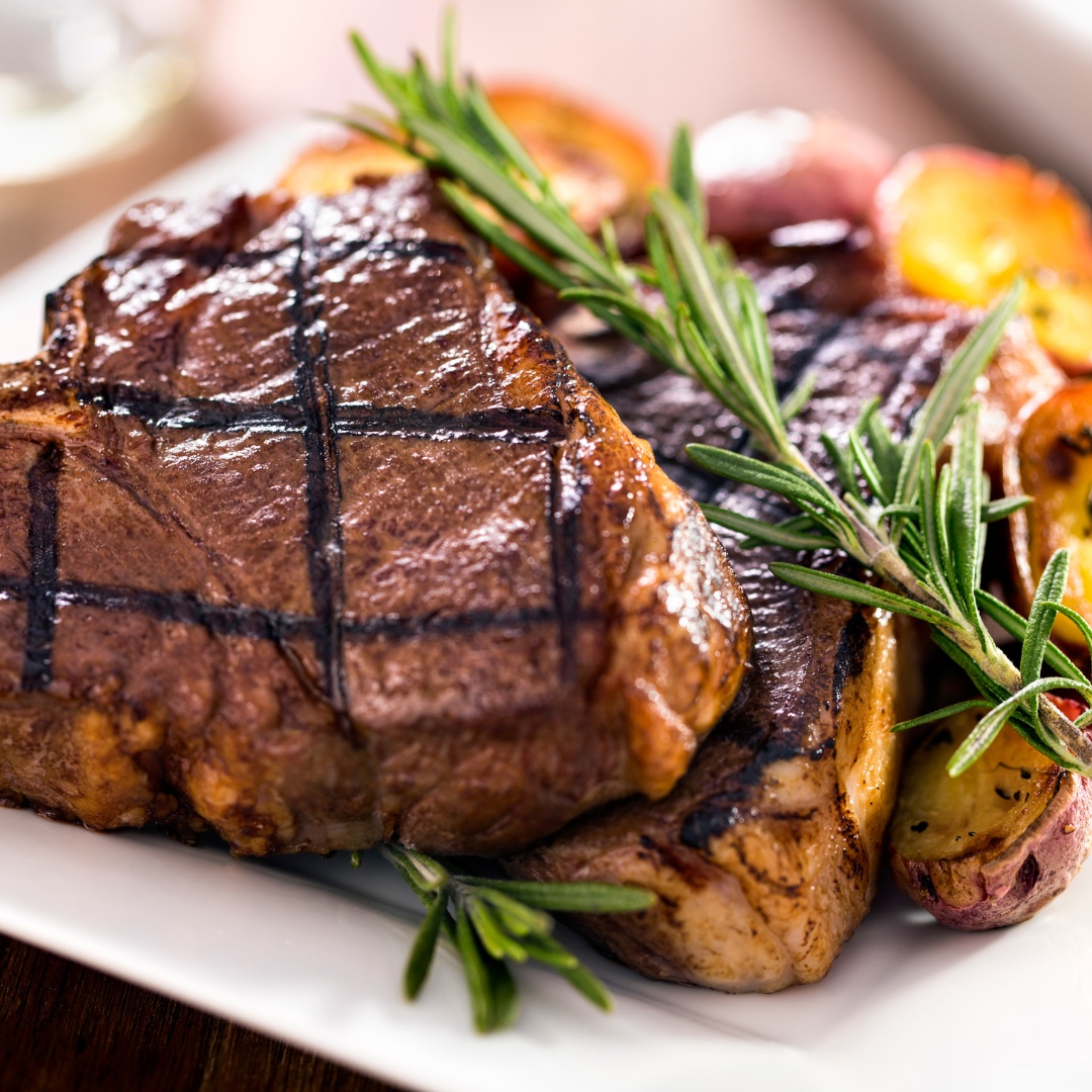 sticky glazed lamb loin chops served on a white plate with rosemary as garnish